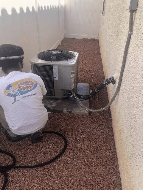 A Century Air tech is cleaning up after repairing a residential AC unit—trust Century Air Inc to get your AC cooling again.