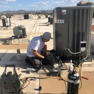 A Century Air technician working on an ac unit located on the roof.